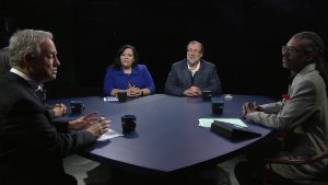 Four people sitting around a table talking.