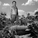 A man standing in a field with plants.