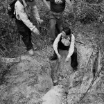 A group of people looking at a hole in the ground.