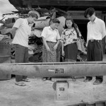 A group of people standing around a boat.