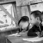 A group of children sitting at a desk.