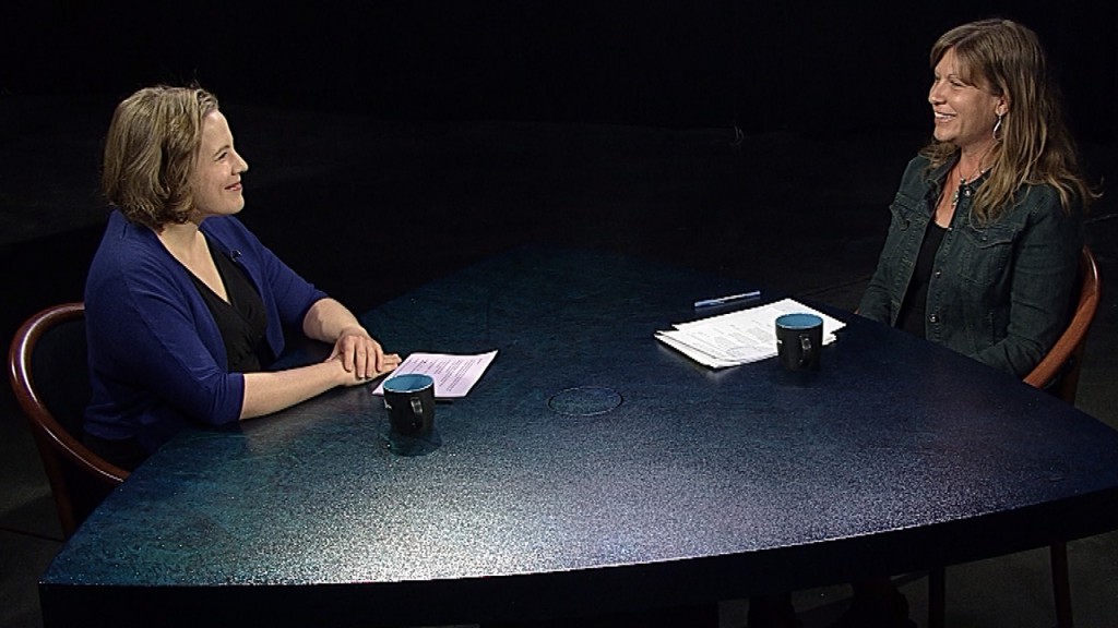 A woman sitting at a table with papers on it.