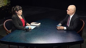 A man and woman sitting at a table talking.