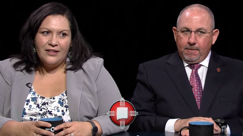 A man and woman sitting at a table with a cup of coffee.