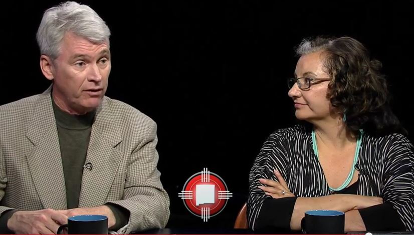 A man and woman sitting at a table talking.