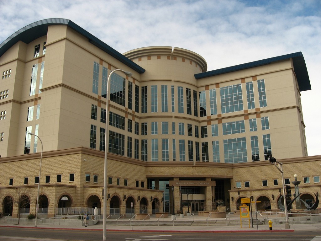 A large tan building on a street corner.