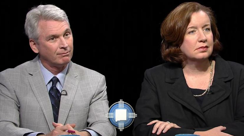 Two people sitting next to each other on a black background.