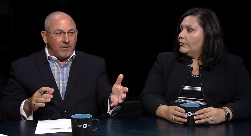 A man and woman sitting at a table talking.