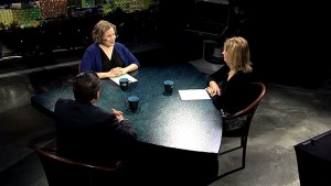 Three people sitting around a table in an interview.