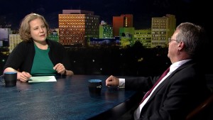 A man and woman sitting at a table in front of a city.
