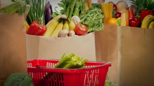 A red basket full of vegetables and fruit.