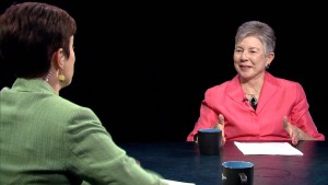 Two women sitting at a table talking to each other.