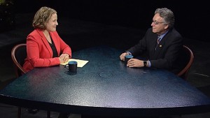 A man and woman sitting at a table talking.