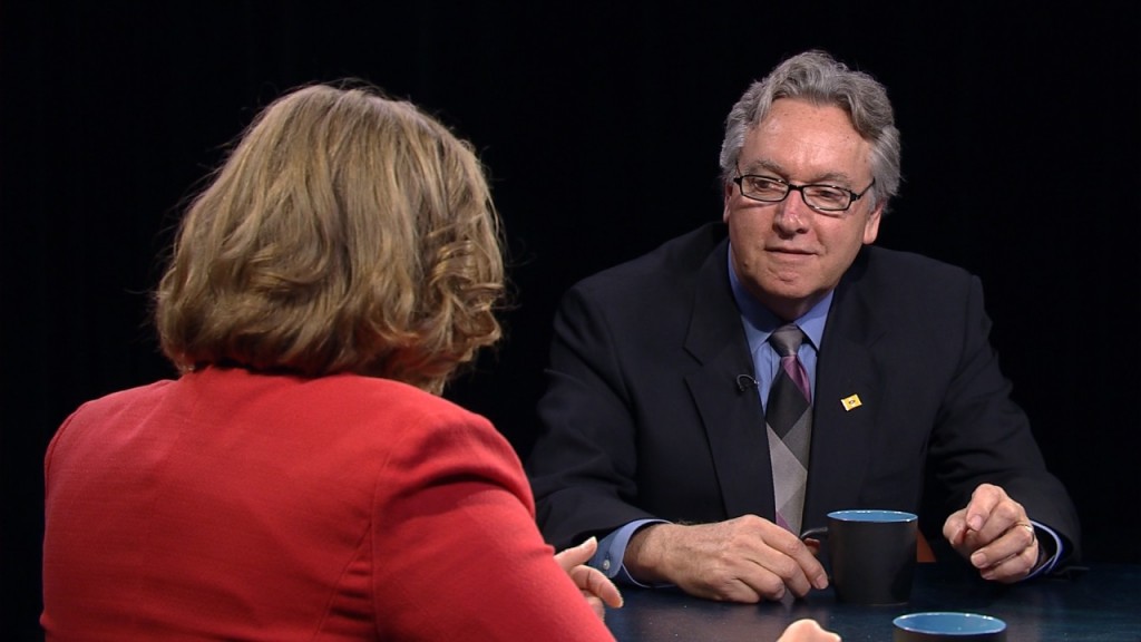 A man and woman sitting at a table talking.