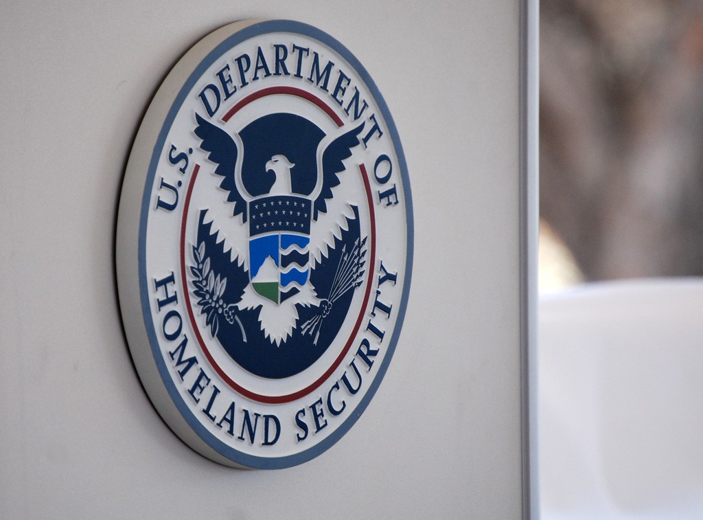 The u s department of homeland security logo is displayed on a wall.