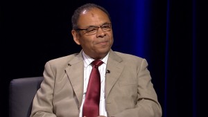 A man in a suit and tie sitting in a chair.