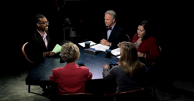 A group of people sitting around a table.