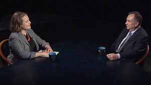 A man and woman sitting at a table talking.