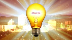 An image of a light bulb in front of a city.