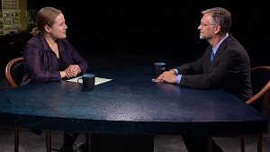 A man and woman sitting at a table talking.