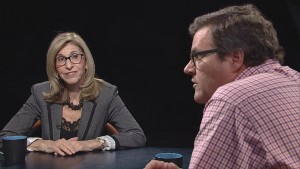 A man and woman sitting at a table talking.