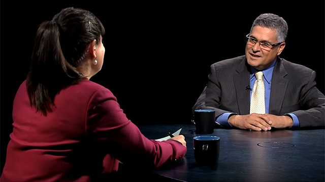 A man and woman sitting at a table talking.