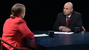 A man and woman sitting at a table talking.