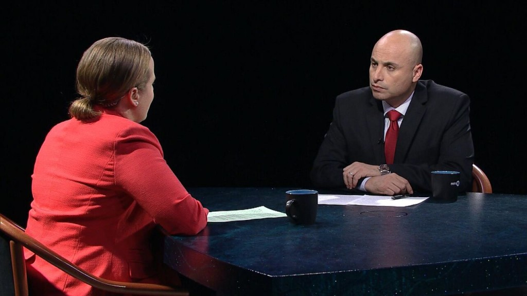 A man and woman sitting at a table talking.