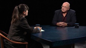 A man and woman sitting at a table talking.