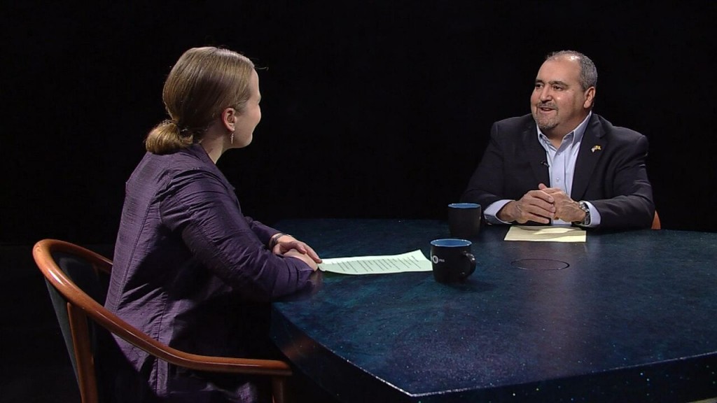A man and woman sitting at a table talking.