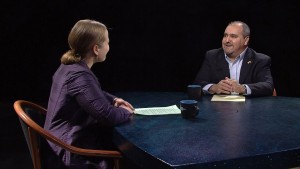 A man and woman sitting at a table talking.
