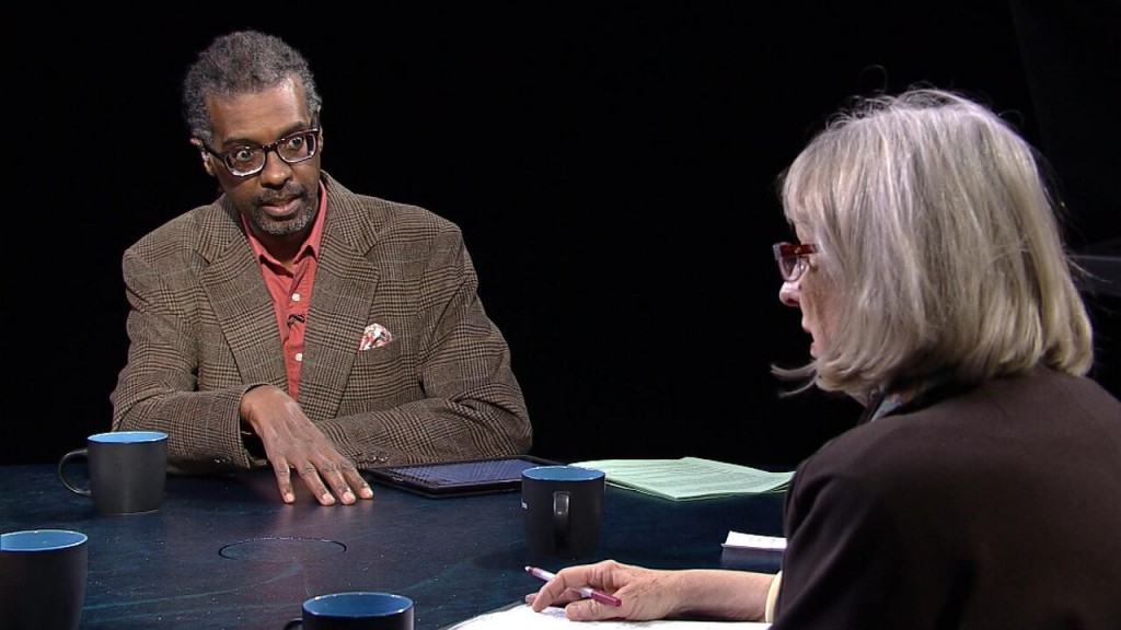 A man and woman sitting at a table talking.