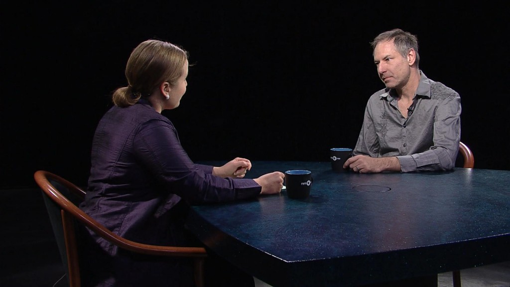 A man and woman sitting at a table talking.