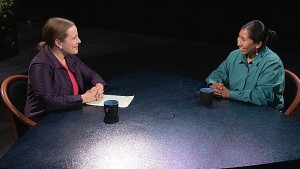 Two women sitting at a table talking.