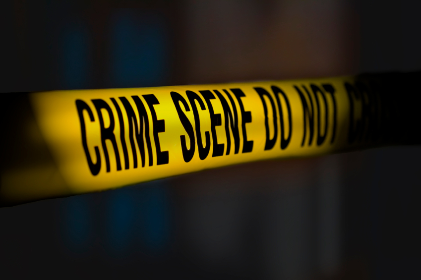 A yellow crime scene tape on a dark background.