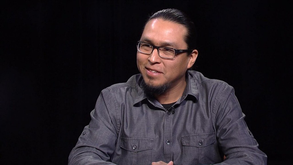 A man with glasses sitting at a table.