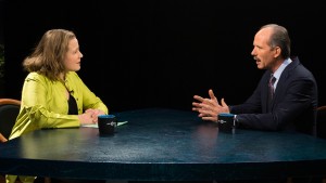 A man and woman sitting at a table talking.