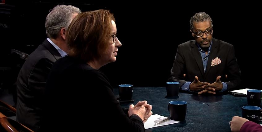 A group of people sitting around a table talking.