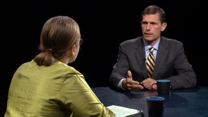 A man and woman sitting at a table talking.