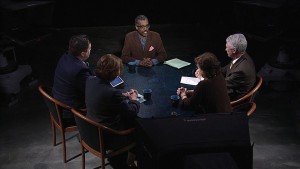 A group of people sitting around a table in a dark room.