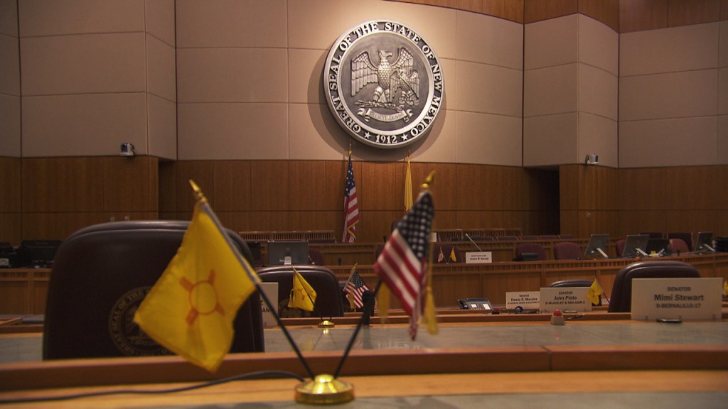 A courtroom with a clock and flags.