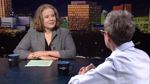 A man and woman sitting at a table in front of a city.