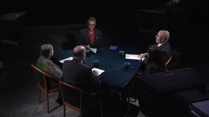 A group of people sitting at a table in a dark room.