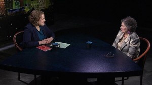 Two women sitting at a table talking.