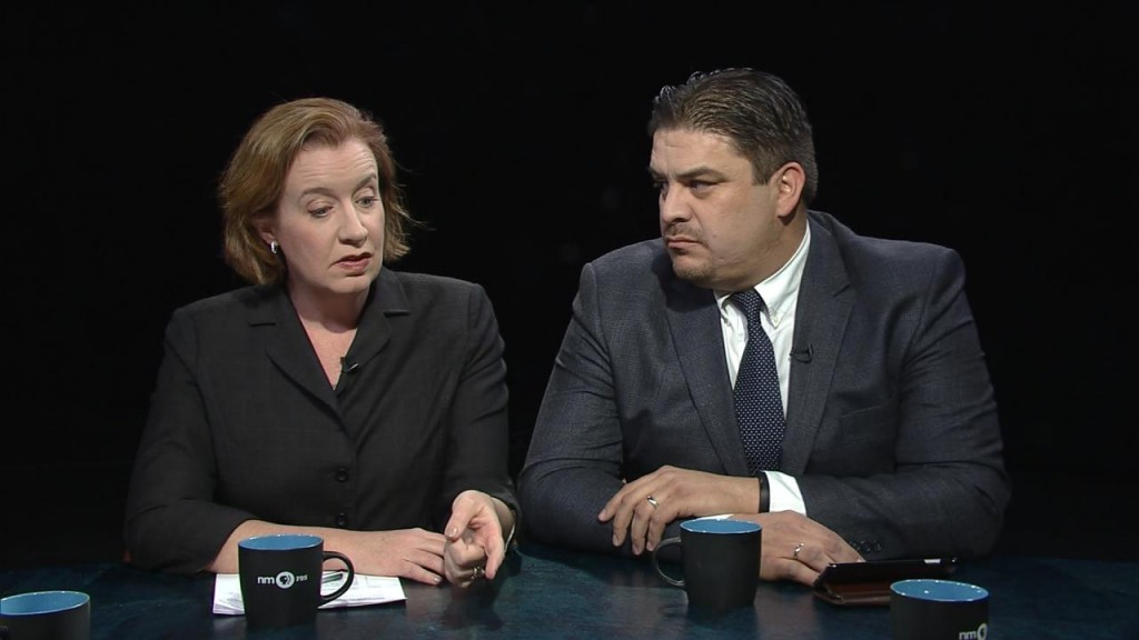 A man and woman sitting at a table with a cup of coffee.