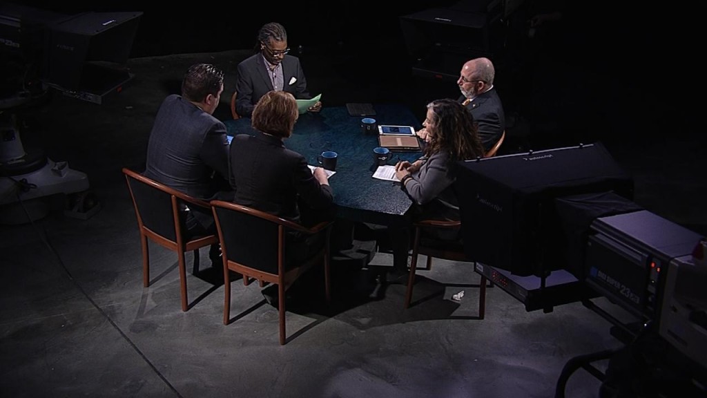 A group of people sitting around a table in a dark room.