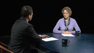 A man and woman sitting at a table talking.