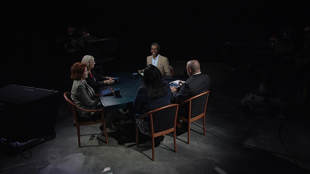 A group of people sitting around a table in a dark room.