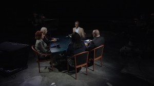 A group of people sitting around a table in a dark room.