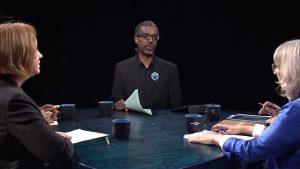A group of people sitting around a table talking.